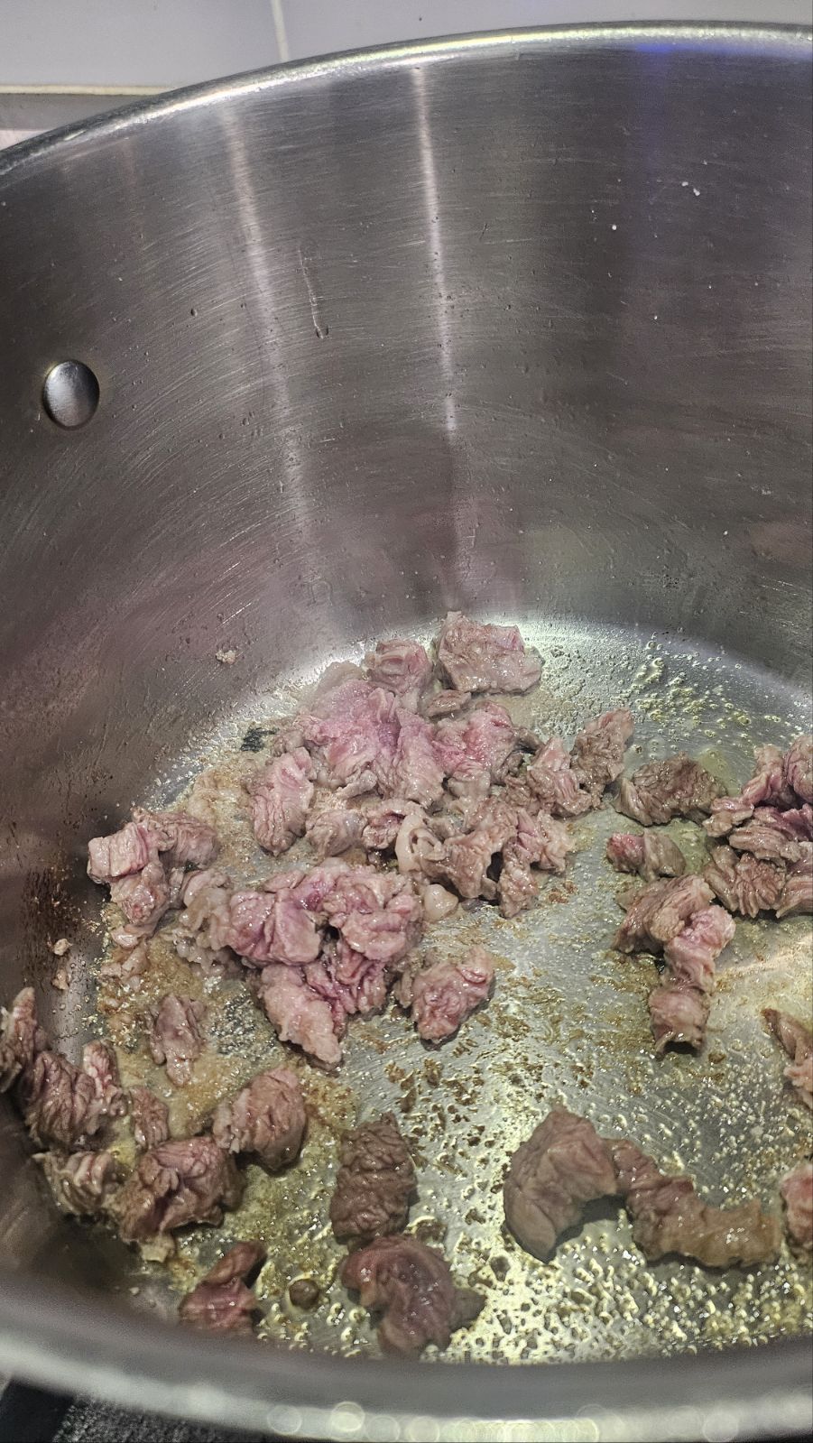 Sautéing the brisket with sesame oil in a pot